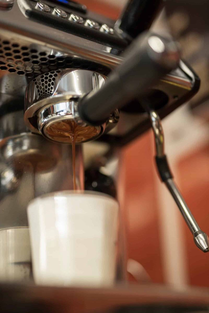 close up coffee pouring into glass with milk scaled